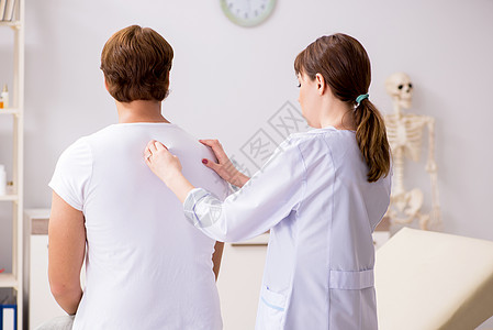 男病人看年轻女医生脊椎按摩师男人访问肌肉职业摩师疼痛触诊治疗脊柱理疗图片