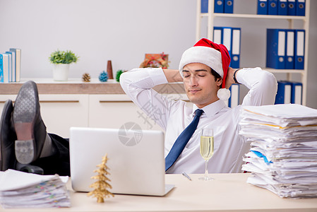 圣诞轮班在办公室工作的年轻工人男人派对假期职场商业人士商务桌子睡眠庆典图片