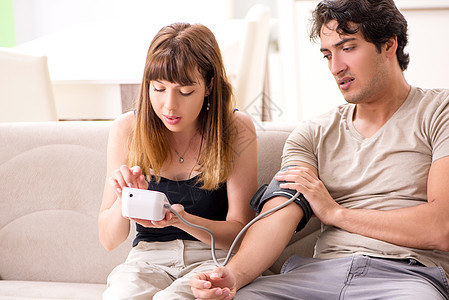 妻子检查丈夫的血压诊断男人监控测试压力计药品护士仪表高血压医师女士高清图片素材