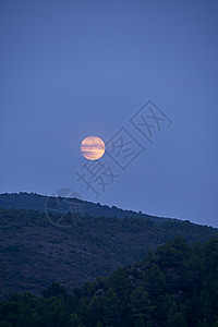 月亮在山之间升起图片
