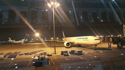 在混凝土铺面候机楼上机场的客机夜间观视图片