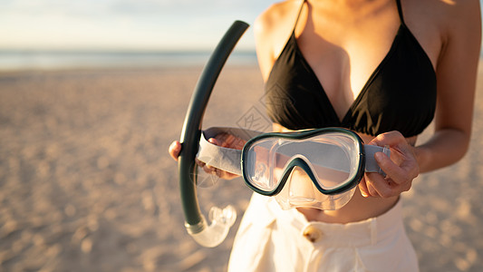 在沙滩上装有潜水面具设备的女人晴天日落比基尼海景运动女孩天空女士游泳旅游图片