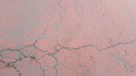 红色损坏的道路或铺有裂缝的道路地面泥路划痕沉积建筑学材料石膏街道侵蚀路面图片
