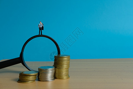 微型人物概念  站在放大镜上寻找财务解决方案的商务人士战略商业硬币生活思考商务银行贷款摄影玩具图片