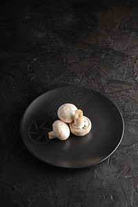 三个冠尼翁蘑菇 在黑盘上吃健康食物 深底黑盘盘子团体厨房营养美食饮食烹饪图片
