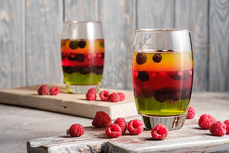 在旧木制板上用玻璃浆果和果莓的果冻甜点杯子明胶覆盆子团体石头乡村醋栗木头营养木板图片