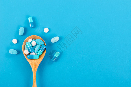 用木勺装药丸制药疼痛止痛药药剂药片科学处方蓝色药物保健图片