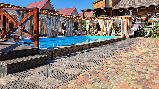 一个有游泳池的院子 太阳休息者 一个环境友好型木柴组成的游乐场 全家都暑假家庭天空营地幻灯片植物酒店潜水波浪棕褐色乐趣图片