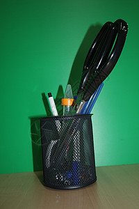 仔细查看装有文具物品的文具罐桌子学校学生铅笔假期彩色知识绿色销售背景图片