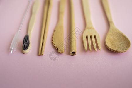 生态友好的竹制餐具套装在粉红色背景的盒子里 零废物概念 一套竹制餐具放在桌子上的一个盒子里 勺子 叉子 刀 牙刷 管子和中国棍子图片