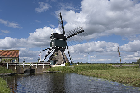 荷兰运河附近传统杜奇风力车 荷兰场地风景农业旅游活力场景游客农村运河日落图片