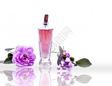 玫瑰花及其喷洒的喷雾或香水 装在一个透明的玻璃瓶里 白色与玫瑰花瓣隔绝图片