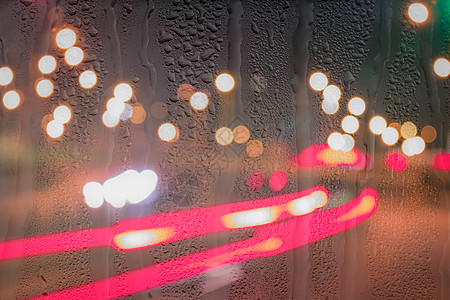 车在雨后移动时有突出重点的头灯运动窗户阴雨背景辉光天气汽车液体城市反射图片