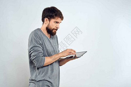 一个手手里拿着平板电脑的男人 互联网科技通讯灰色夹克光背景的白衣软垫男性公司药片衬衫商务商业工作室人士技术图片
