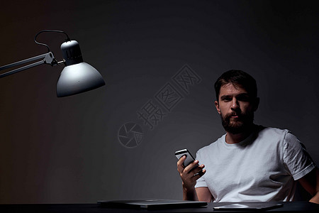 手持手机 深底背景和铁灯种植工作观的有移动电话的男商务人士文档工作室商务人士房间情感商业沉思电脑房子图片