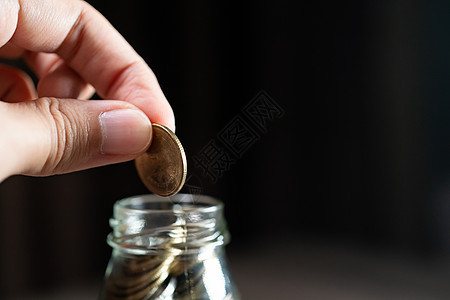 用手把硬币放在玻璃罐里 省钱图片