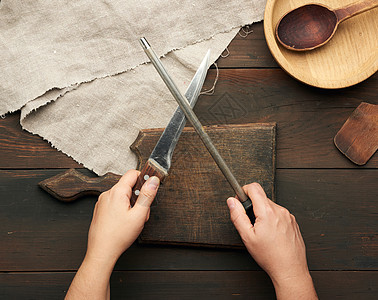 女用手握着厨房刀和手柄的磨刀剃刀金属女性刀刃食物桌子用具棕色烹饪工作图片