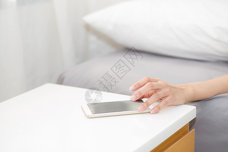 女人的手在醒来时当电话通话时关掉报警器唤醒轨枕细胞手机病人毯子时间女性休息警报图片