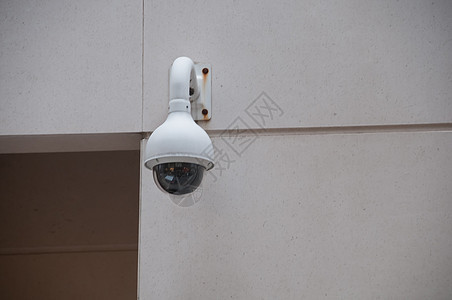 安全闭路电视圆顶摄像头连接在门旁边的白色墙壁上图片