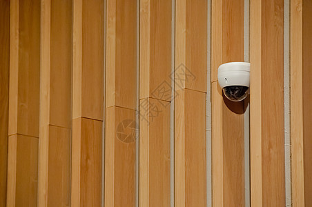 现代白色闭路电视安全摄像头顶附在木墙上图片