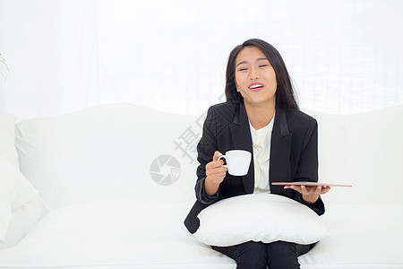 坐在沙发上的年轻亚洲女商务人士的美丽肖像互联网女孩手机人士商务管理人员女性工作咖啡技术图片