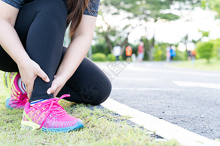 亚裔女性在公园的路上跑时用手握着脚踝 因锻炼概念而受伤赛跑者阳光膝盖痛苦成人运动肌肉运动员女士髌骨图片