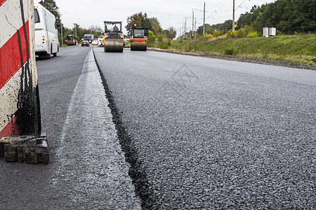 一大层新鲜的热沥青 浅景深中的沥青原料层 滚子在新的道路上滚动新鲜的热沥青 道路建设 修建一条新路维修街道材料路线路面柏油墙纸滚背景