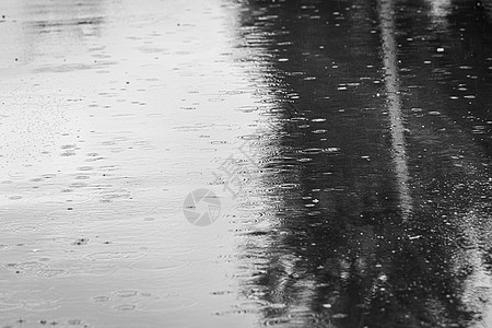 雨滴落到水坑里 在水上留下圆圈人行道气泡天气飞溅季节阴雨波纹液体沥青水滴图片