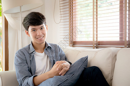 长着肖像的年轻英俊的亚洲男人 在沙发上舒适地睡着放松男性长椅假期房子人士福利闲暇商务房间快乐图片