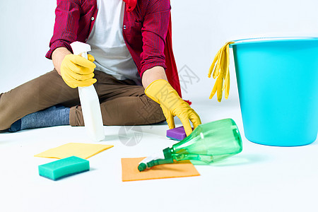 一个穿着红色雨衣的男人坐在家里洗地板 提供服务洗涤剂配件灰尘工作生活刷子家政职业房间地面女佣工人图片