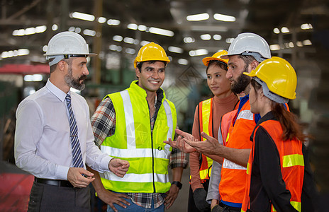 男性工业工程师与工厂工人交谈 他们在重工业制造工厂工作生产承包商检查员力量机械微笑经理头盔作坊工程图片
