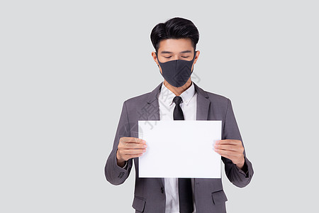 戴着面罩的年轻亚洲商务人士画像展示了白色背景中孤立的纸片 因 covid19 危机而失业的商务人士 covid 的经济和流行病 图片