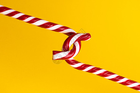黄色背景的糖果甘蔗棒棒棒糖 圣诞甜点新年假期庆典传统装饰品条纹食物薄荷螺旋焦糖图片