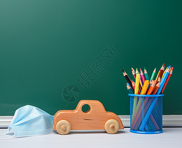 一次性医疗面罩 绿色粉笔板背景的学校文具 学校检疫概念;以及图片