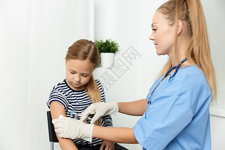 一名身穿蓝色大衣的女医生将儿童注射到手药品注射器卫生胰岛素医疗保险女士药物手臂治疗儿科图片