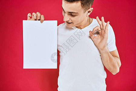 持有纸质复制空间T恤红色背景材料的情绪型男子成人广告牌卡片男人商业男性横幅微笑办公室快乐图片