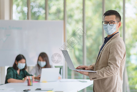 企业雇员在办公室工作时戴面罩 以保持遵守公司保有的卫生政策商业危机职业常态打扫技术商务头脑智力流感图片