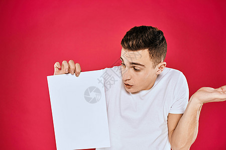 持有纸质复制空间T恤红色背景材料的情绪型男子广告牌推介会衬衫商业卡片男人幸福快乐商务横幅图片