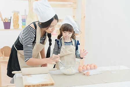 亚裔母亲和女儿正在准备钱 在度假时在厨房做蛋糕 然后在饭室做蛋糕女孩幸福厨师家庭食物教育快乐假期乐趣孩子图片