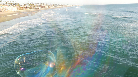 在夏季背景的海洋码头上吹肥皂泡 梦想幸福和魔法的创意浪漫隐喻概念 童年幻想自由的抽象象征海岸海浪场景海滩想像力气泡创造力海岸线彩图片