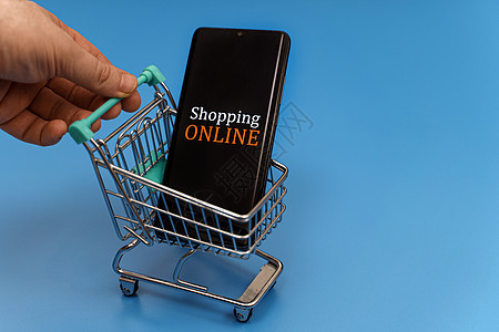 蓝色背景的智能手机购物车 在线购物概念 笑声商业顾客互联网营销零售电子商务技术命令网络商品图片