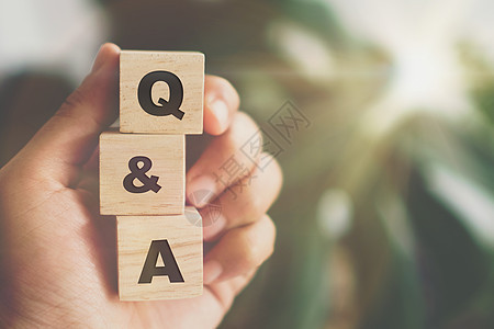 在木制立方体上 用有背景的手握着Q和字母表 问答的含义问题论坛商业社区男人解决方案帮助服务网络教育图片