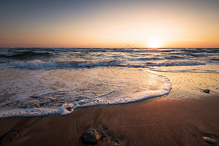 美丽的日出在海面上海浪晴天云景旅行海岸假期天空太阳金子热带图片