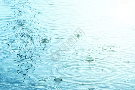 雨滴在水面上形成同心圆和水滴图片