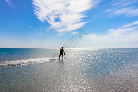 风筝冲浪者在光滑的蔚蓝水面上冲浪 休闲运动 一个人在海水中骑风筝冲浪 极限运动 跳木板锻炼飞行跳跃波浪航班行动享受男性竞赛图片