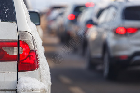 冬季白天背景的白车尾灯 下雪和模糊交通情况;图片