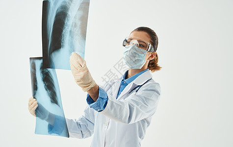 身穿医疗长袍的医生 带着X光照片 用手拍着探照放射科职业检查医师骨骼外科医院疾病照相护士图片