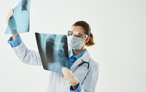 身穿医疗长袍的医生 带着X光照片 用手拍着探照病人胸部诊所药品护士女士扫描射线诊断疾病图片