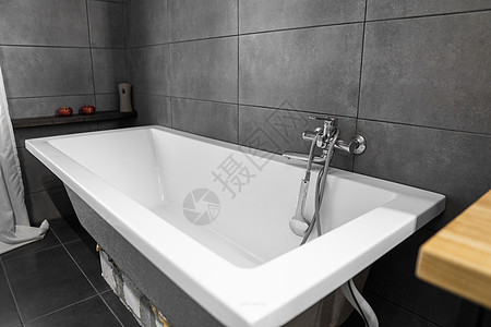 浴室内部墙上贴着灰色瓷砖 时尚的白色浴缸配有银色水龙头 浴室内部的极简主义植物房间住宅淋浴地面制品陶瓷风格洗澡洗手间图片