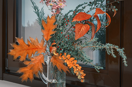 秋天的花朵和窗台上的叶子季节菊花花瓣树叶周年植物金子花束橙子浆果图片